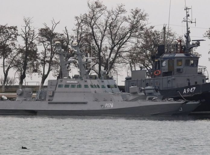Seized Ukrainian ships, small armoured artillery ships and a tug boat, are seen anchored in a port of Kerch